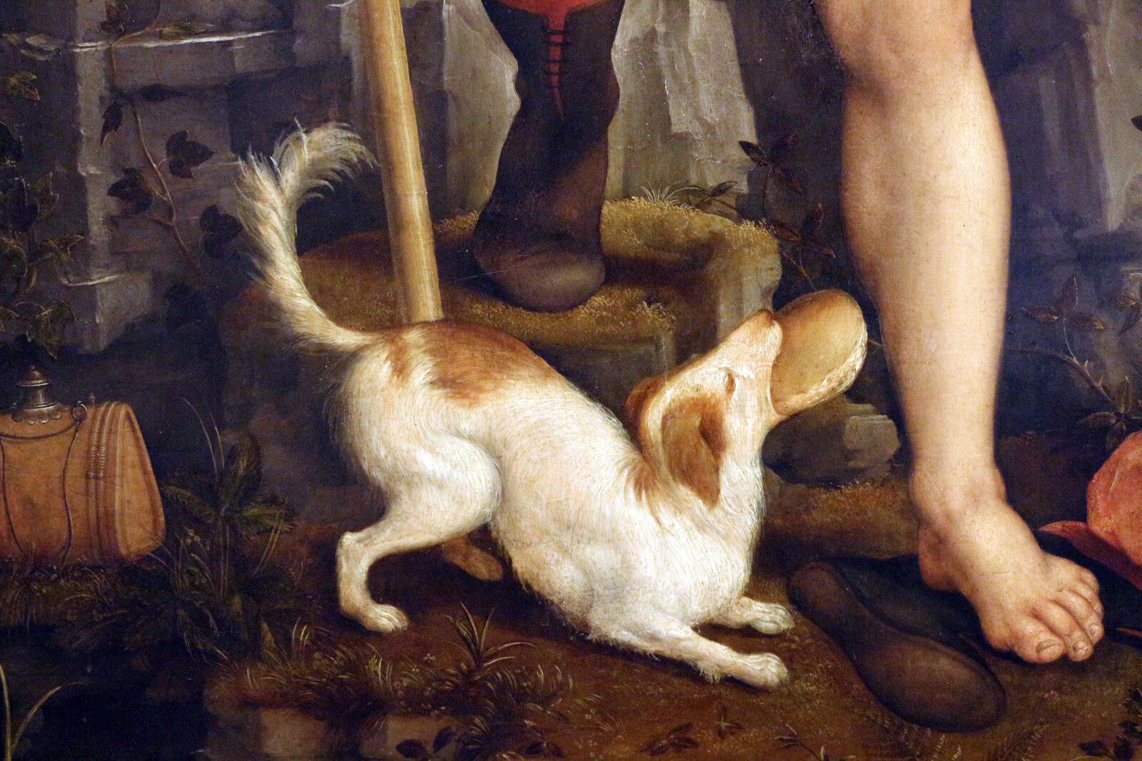 Detail of a Renaissance painting showing a small white and tan dog at a figure's feet, carrying a loaf of bread in its mouth
